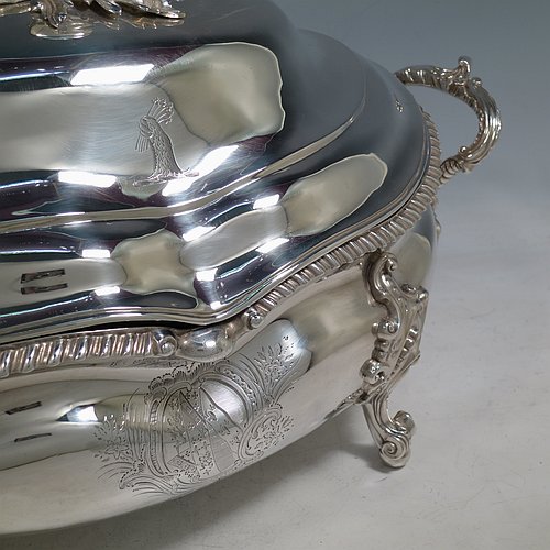 An Antique Early Victorian Sterling Silver soup tureen in a Regency style, having an oval bellied body with an applied wavy gadroon border, a domed pull-off cover with a cast pumpkin and leaf handle, with two cast scroll and shell side handles, and sitting on four cast scroll feet with floral shoulders. Made by William Moulson of London in 1840. The dimensions of this fine hand-made antique silver soup tureen and cover are length 43 cms (17 inches), height 25.5 cms (10 inches), width 24 cms (9.5 inches), and it weighs approx. 3,195g (103 troy ounces). Please note that this antique Victorian silver soup tureen is crested on the main body and cover.