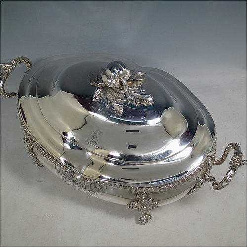 An Antique Early Victorian Sterling Silver soup tureen in a Regency style, having an oval bellied body with an applied wavy gadroon border, a domed pull-off cover with a cast pumpkin and leaf handle, with two cast scroll and shell side handles, and sitting on four cast scroll feet with floral shoulders. Made by William Moulson of London in 1840. The dimensions of this fine hand-made antique silver soup tureen and cover are length 43 cms (17 inches), height 25.5 cms (10 inches), width 24 cms (9.5 inches), and it weighs approx. 3,195g (103 troy ounces). Please note that this antique Victorian silver soup tureen is crested on the main body and cover.