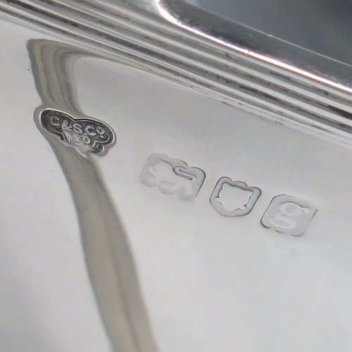 An Antique Edwardian Sterling silver Neoclassical style soup tureen, having a pull-off lid with an urn-shaped finial and cut-out slot for a ladle, with hand-chased shoulders, applied reeded borders, two reeded scroll side-handles, and all sitting on a pedestal foot. Made by Goldsmiths & Silversmiths of London in 1902. The dimensions of this fine hand-made antique silver soup tureen and cover are height 23 cms (9 inches), length including handles 38 cms (15 inches), width 20 cms (8 inches), and it weighs approx. 1,615 (52 troy ounces). Please note that this item is crested on lid and body.