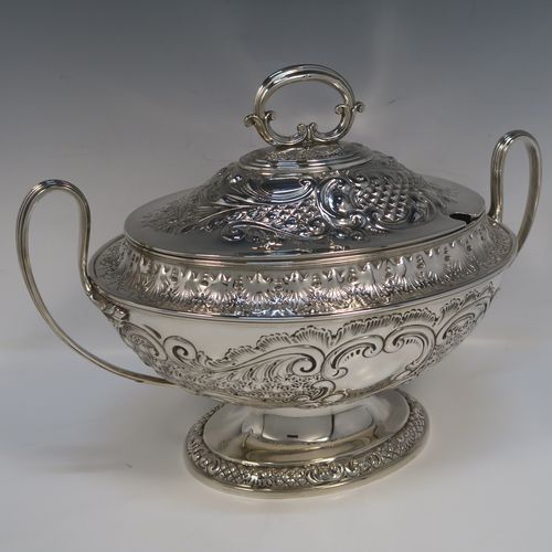 A beautiful Antique Victorian Silver Plated soup tureen, having a hand-chased oval body with floral and scroll decoration, a pull-off cover with cast finial handle and soup ladle cut-out, together with two reeded loop side-handles, and all sitting on a pedestal foot. This handsome silver-plated soup tureen and cover was made by Henry Cook and Co., of Sheffield in ca. 1880. The dimensions of this fine hand-made antique silver-plated soup tureen and cover are height 27 cms (10.5 inches), and width (across handles) 37 cms (14.5 inches).   