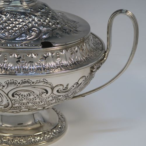 A beautiful Antique Victorian Silver Plated soup tureen, having a hand-chased oval body with floral and scroll decoration, a pull-off cover with cast finial handle and soup ladle cut-out, together with two reeded loop side-handles, and all sitting on a pedestal foot. This handsome silver-plated soup tureen and cover was made by Henry Cook and Co., of Sheffield in ca. 1880. The dimensions of this fine hand-made antique silver-plated soup tureen and cover are height 27 cms (10.5 inches), and width (across handles) 37 cms (14.5 inches).
