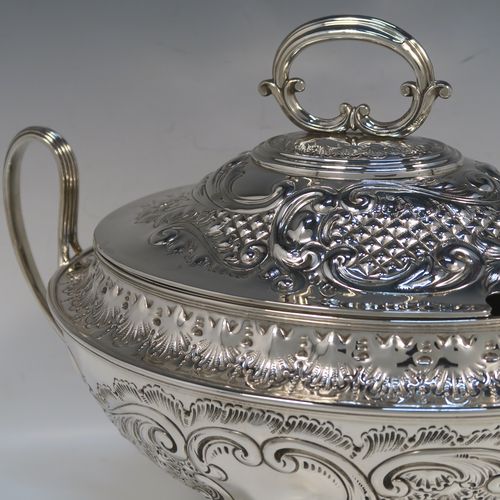 A beautiful Antique Victorian Silver Plated soup tureen, having a hand-chased oval body with floral and scroll decoration, a pull-off cover with cast finial handle and soup ladle cut-out, together with two reeded loop side-handles, and all sitting on a pedestal foot. This handsome silver-plated soup tureen and cover was made by Henry Cook and Co., of Sheffield in ca. 1880. The dimensions of this fine hand-made antique silver-plated soup tureen and cover are height 27 cms (10.5 inches), and width (across handles) 37 cms (14.5 inches).