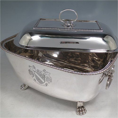 An Antique Georgian Sterling Silver soup tureen, having a plain rectangular body with rounded corners, a pull-off lid cover with an asparagus loop handle, with applied gadroon borders, two cast lion-mask loop side handles, and all sitting on four cast lions-paw feet. Made by William Bennett of London in 1805. The dimensions of this fine hand-made antique silver soup tureen and cover are height 21 cms (8.25 inches), length 28 cms (11 inches), width 20 cms (8 inches), and it weighs approx. 1,860 (60 troy ounces). Please note that this antique soup tureen is crested on one side.
