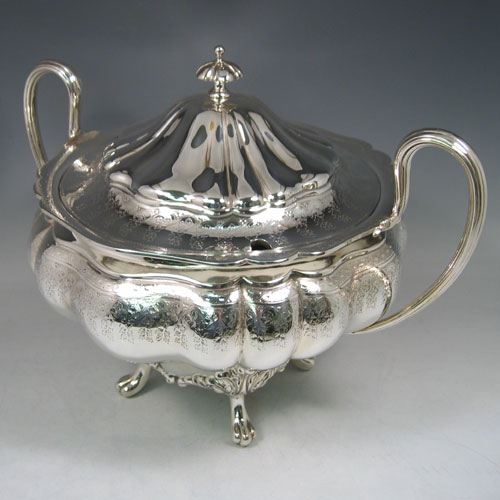 An Antique Victorian Silver Plated soup tureen, having a hand-chased and engraved body with melon-style lobes and floral decoration, a pull-off cover with cast finial, with two reeded loop side-handles, and all sitting on four cast foliate feet. Made by the Mappin Brothers in ca. 1870. The dimensions of this fine hand-made antique silver-plated soup tureen are height 26 cms (10.25 inches), and width (across handles) 37 cms (14.5 inches).