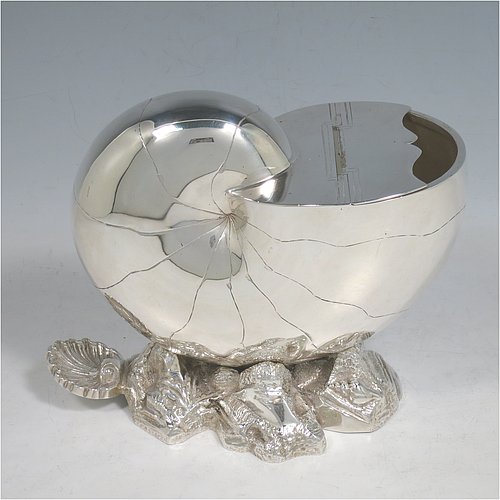 An Antique Victorian Silver Plated spoon warmer, in the shape of a Nautilus shell, having a hand-chased body with invisibly hinged lid opening, and all sitting on a cast rock base with shell thumb-piece. Made by the Atkin Brothers of Sheffield in ca. 1880. The dimensions of this fine hand-made silver-plated spoon warmer are length 16.5 cms (6.5 inches), height 14 cms (5.5 inches), and width 9 cms (3.5 inches).    