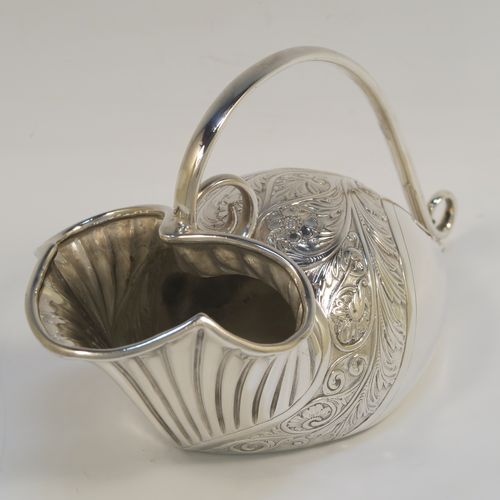 A beautiful and unusual Antique Victorian Silver Plated spoon warmer, in the shape of a fly trap pitcher plant, having a hand-chased body with fluted, leaf, and scroll decoration, and a scroll tendril handle. This pretty spoon warmer was made in ca. 1880 and has a design registration mark and a retailers mark for Glasgow. The dimensions of this fine hand-made antique silver-plated spoon warmer are length 20 cms (8 inches), height 10 cms (4 inches), and width 8.5 cms (3.3 inches).