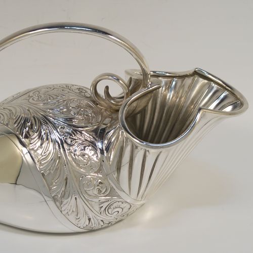 A beautiful and unusual Antique Victorian Silver Plated spoon warmer, in the shape of a fly trap pitcher plant, having a hand-chased body with fluted, leaf, and scroll decoration, and a scroll tendril handle. This pretty spoon warmer was made in ca. 1880 and has a design registration mark and a retailers mark for Glasgow. The dimensions of this fine hand-made antique silver-plated spoon warmer are length 20 cms (8 inches), height 10 cms (4 inches), and width 8.5 cms (3.3 inches).