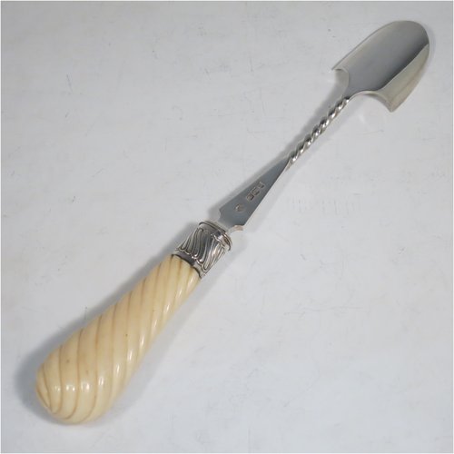 An Antique Victorian Sterling Silver and Ivory handled stilton cheese scoop, having a hand-cut spirally fluted handle, a hand-chased swirl-fluted ferrule, and a twisted stem with plain scoop. Made by William Hutton of London in 1899. The dimensions of this fine hand-made antique silver stilton cheese scoop are length 24 cms (9.5 inches).