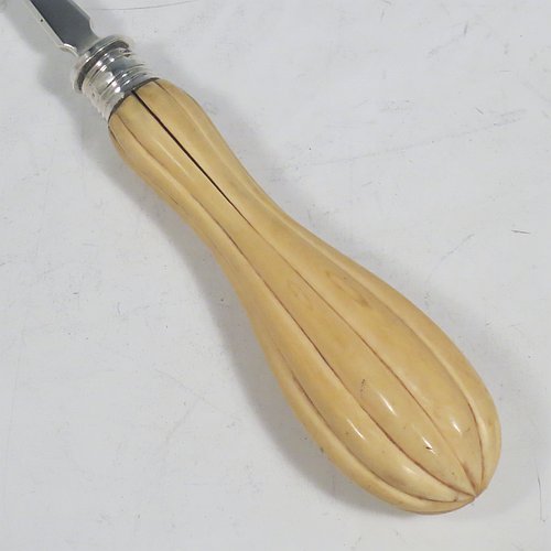 An Antique Victorian Sterling Silver and bone handled stilton cheese scoop, having a hand-cut fluted handle, a hand-chased reeded ferrule, and a plain square cross-section stem with robust scoop. Made by Martin Hall & Co., of Sheffield in 1860. The dimensions of this fine hand-made antique silver and bone-handled stilton cheese scoop are length 21.5 cms (8.5 inches).