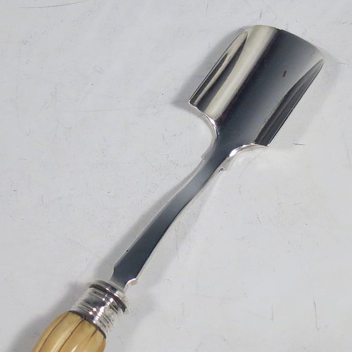 An Antique Victorian Sterling Silver and bone handled stilton cheese scoop, having a hand-cut fluted handle, a hand-chased reeded ferrule, and a plain square cross-section stem with robust scoop. Made by Martin Hall & Co., of Sheffield in 1860. The dimensions of this fine hand-made antique silver and bone-handled stilton cheese scoop are length 21.5 cms (8.5 inches).