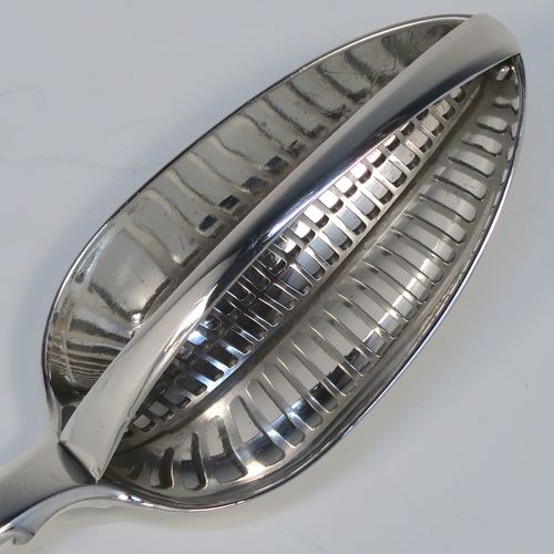 A rare and handsome Antique Georgian Sterling Silver   mutton strainer spoon, having a very plain Fiddle pattern handle with pip on reverse, and a plain oval bowl, attached to which is a vertical strainer section. This elegant silver serving and strainer spoon was made by William Eley and William Fern of London in 1805. The dimensions of this fine hand-made antique silver strainer spoon are length 30 cms (11.75 inches), and it weighs approx. 174g (5.6 troy ounces).   