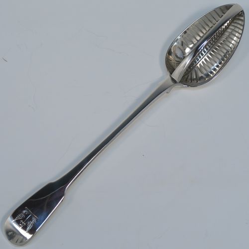 A rare and handsome Antique Georgian Sterling Silver   mutton strainer spoon, having a very plain Fiddle pattern handle with pip on reverse, and a plain oval bowl, attached to which is a vertical strainer section. This elegant silver serving and strainer spoon was made by William Eley and William Fern of London in 1805. The dimensions of this fine hand-made antique silver strainer spoon are length 30 cms (11.75 inches), and it weighs approx. 174g (5.6 troy ounces).   