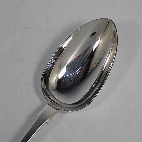 An Antique Georgian Sterling Silver heavy stuffing spoon in the Fiddle pattern, having a very plain handle with pip on reverse, and a plain oval bowl with shoulders above. Made by Clement Cheese of London in 1828. The dimensions of this fine hand-made antique silver stuffing spoon are length 30.5 cms (12 inches), and it weighs approx. 152g (4.9 troy ounces).