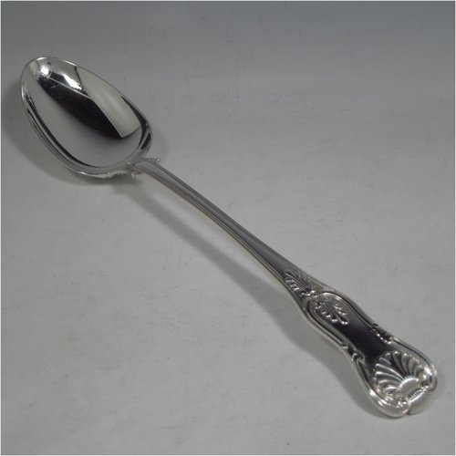 An Antique Georgian sterling silver stuffing spoon in the double-struck Kings pattern, having a fancy handle with hand-chased shell, scroll, and reeded decoration, and a plain oval bowl with shoulders above. Made by William Eley & William Fearn of London in 1823. The dimensions of this fine hand-made silver stuffing spoon are length 31 cms (12.25 inches), and it weighs approx. 200g (6.5 troy ounces).