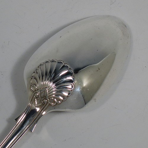 A heavy Sterling Silver stuffing spoon in the double-struck Kings pattern, having a fancy handle with hand-chased shell, scroll, and reeded decoration, and a plain oval bowl with shoulders above, and shell on reverse. Made in London in 1978. The dimensions of this fine hand-made silver stuffing spoon are length 31 cms (12.25 inches), and it weighs approx. 253g (8.2 troy ounces).