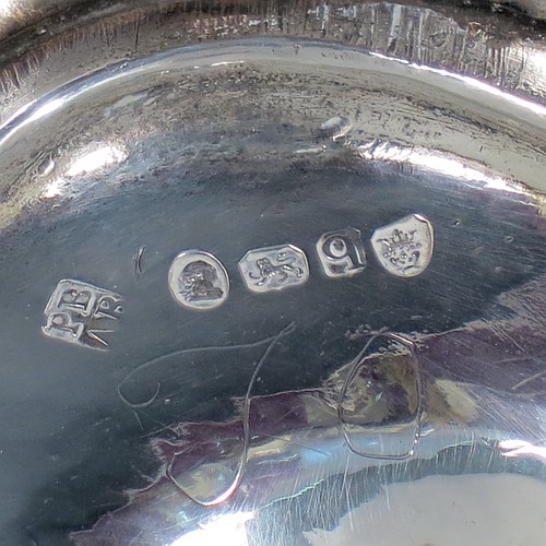 An Antique Georgian Sterling Silver sugar basket, having an oval bellied body with hand-chased half-fluting, with applied reeded borders, a hinged and reeded swing-handle, and sitting on a pedestal foot. Made by Peter & Anne Bateman of London in 1791. The dimensions of this fine hand-made antique silver sugar basket are height (inc. handle) 15 cms (6 inches), length 14 cms (5.5 inches), and it weighs approx. 198g (6.4 troy ounces).