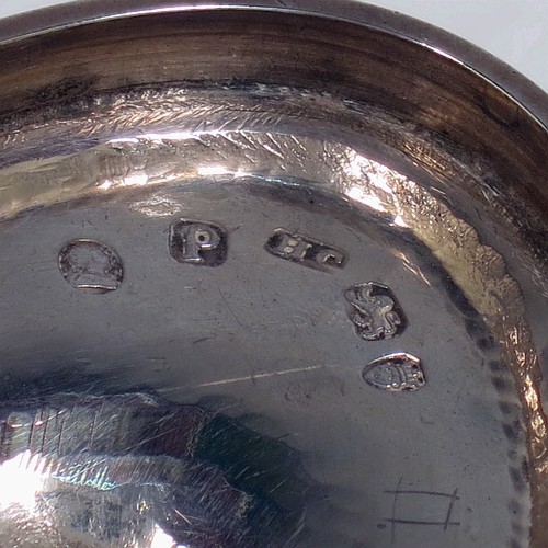 A very pretty Antique Georgian Sterling Silver sugar basket, having an oval bellied body in a Neoclassical style with hand-engraved floral and swag decoration, applied reeded borders, a hinged and reeded swing-handle, and sitting on a pedestal foot. Made by Henry Chawner of London in 1790. The dimensions of this fine hand-made antique silver sugar basket are height (inc. handle) 12.5 cms (5 inches), length 12.5 cms (5 inches), and it weighs approx. 151g (4.9 troy ounces).
