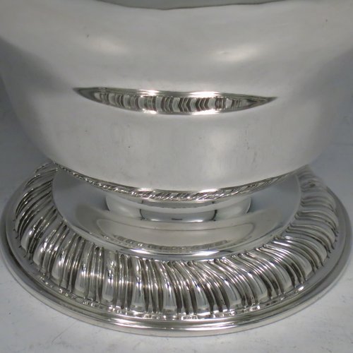 A Sterling Silver large sugar bowl, in a Georgian style, having a plain round baluster body, with an applied gadroon border, two scroll side-handles with Anthemion leaf thumb-pieces, a gold-gilt interior, and all sitting on a pedestal foot with hand-chased fluted decoration. Made by Charles Townley & John Thomas of London in 1928. The dimensions of this fine hand-made silver sugar bowl are height 13.5 cms (5.25 inches), spread across handles 19 cms (7.5 inches), and it weighs approx. 448g (14.5 troy ounces).   