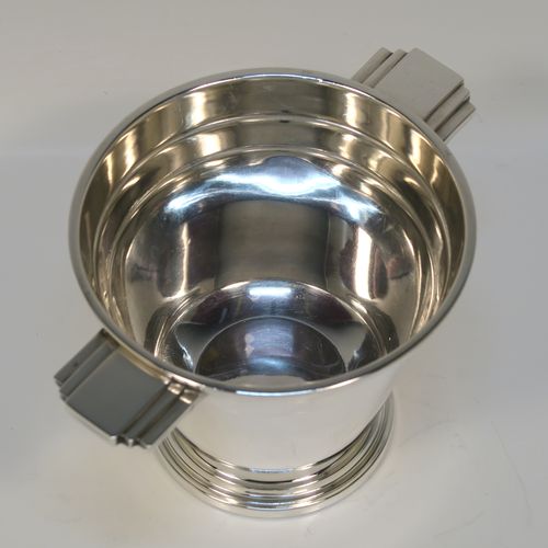 A very stylish Art Deco Sterling Silver sugar bowl, having a round body with tapering sides, with hand-chased reeded decoration, with two cast and stepped side-handles, and sitting on a pedestal foot. This very elegant Art Deco sugar bowl was made by Walker and Hall of Sheffield in 1943. The dimensions of this fine hand-made silver sugar bowl are height 8.5 cms (3.3 inches), diameter at top 10 cms (4 inches), and it weighs approx. 210g (6.8 troy ounces).   