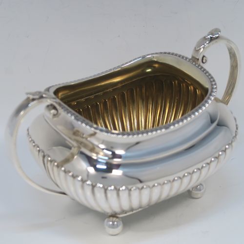 A very handsome Antique Victorian large Sterling Silver sugar bowl, having a rounded rectangular and bellied body, with hand-chased half-fluted decoration, two scroll side-handles, an applied gadroon top border, a gold-gilt interior, and all sitting on four ball feet. This elegant silver sugar bowl was made by James Dixon and Sons of Sheffield in 1885. The dimensions of this fine hand-made antique silver sugar bowl are length (inc. handles) 19 cms (7.5 inches), height 11 cms (4.25 inches), width 11.5 cms (4.5 inches), and it weighs approx. 410g (12 troy ounces).   