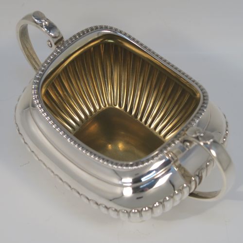 A very handsome Antique Victorian large Sterling Silver sugar bowl, having a rounded rectangular and bellied body, with hand-chased half-fluted decoration, two scroll side-handles, an applied gadroon top border, a gold-gilt interior, and all sitting on four ball feet. This elegant silver sugar bowl was made by James Dixon and Sons of Sheffield in 1885. The dimensions of this fine hand-made antique silver sugar bowl are length (inc. handles) 19 cms (7.5 inches), height 11 cms (4.25 inches), width 11.5 cms (4.5 inches), and it weighs approx. 410g (12 troy ounces).   