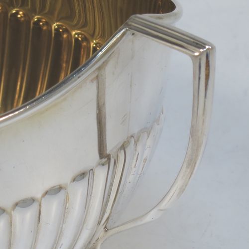 A handsome Antique Edwardian Sterling Silver sugar bowl in a Queen Anne style, having an oval body with hand-chased half-fluted decoration and a gold-gilt interior, two side handles with reeded decoration, and sitting on a collet foot. Made by Goldsmiths and Silversmiths of London in 1908. The dimensions of this fine hand-made antique silver sugar bowl are length 15 cms (6 inches), width 9.5 cms (3.75 inches), height eight 8.5 cms (3.3 inches), and it weighs approx. 157g (5 troy ounces).