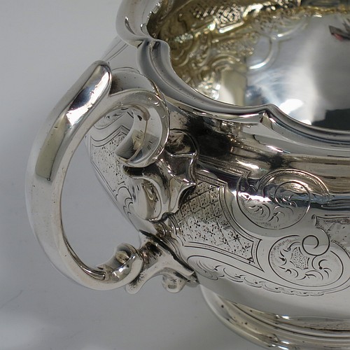 An Antique late Georgian (William IV) Sterling Silver sugar bowl, having a round bellied body with hand-chased floral decoration, an applied lobed top border, with two scroll side handles, and sitting on a collet foot. Made by the Barnard Brothers of London in 1837. The dimensions of this fine hand-made antique silver sugar bowl are height 10 cms (4 inches), width across handles 21.5 cms (8.5 inches), and it weighs approx. 374g (12 troy ounces).