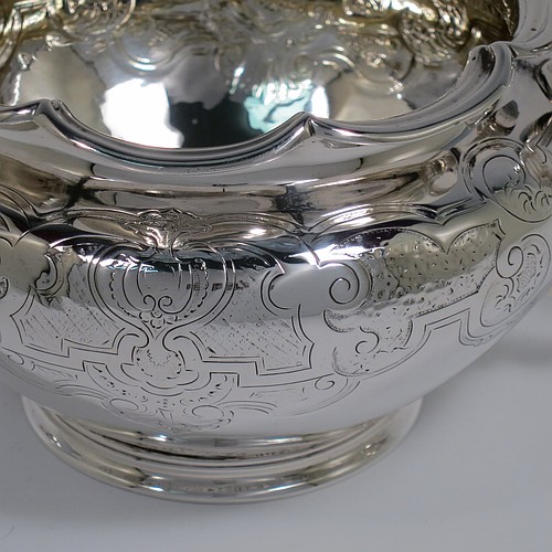 An Antique late Georgian (William IV) Sterling Silver sugar bowl, having a round bellied body with hand-chased floral decoration, an applied lobed top border, with two scroll side handles, and sitting on a collet foot. Made by the Barnard Brothers of London in 1837. The dimensions of this fine hand-made antique silver sugar bowl are height 10 cms (4 inches), width across handles 21.5 cms (8.5 inches), and it weighs approx. 374g (12 troy ounces).