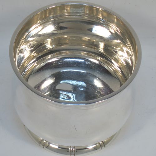 A very elegant and heavy Sterling Silver sugar bowl, having a plain round bellied body, with an applied top reeded border, and all sitting on a pedestal foot with hand-chased fluted decoration. Made by George Tarratt of London in 1971. The dimensions of this fine hand-made silver sugar bowl are height 8 cms (3 inches), diameter at lip 9 cms (3.5 inches), and it weighs approx. 244g (7.9 troy ounces).   