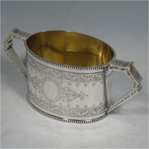 An Antique Victorian Sterling silver sugar and creamer set, having oval bodies with hand-engraved floral decoration, applied beaded borders, gold-gilt interiors, and angular handles. Made by Goldsmiths & Silversmiths of London in 1881. The dimensions of this fine hand-made antique silver cream and sugar set are height of creamer 9 cms (3.5 inches), length of sugar bowl 16 cms (6.25 inches), and with a total weight approx. 303g (9.8 troy ounces).