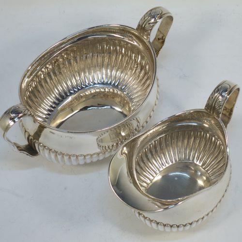 A pretty Antique Victorian Sterling Silver sugar bowl and cream jug set, having oval bellied bodies with hand-chased half-fluted decoration, applied rope-twist borders, scroll side-handles with anthemion leaf thumb-pieces, and all sitting on collet feet. Made by Frederick Bradford Macrea of London in 1887. The dimensions of this fine hand-made antique silver sugar and creamer set are length of sugar bowl (inc. handles) 16.5 cms (6.5 inches), height 9 cms (3.5 inches), width 9.5 cms (3.75 inches), and with a total weight of approx. 310g (10 troy ounces).