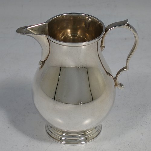 A Sterling Silver sugar and creamer set, having plain round bellied bodies, applied reeded borders, a sparrow-beak spout, and sitting on collet feet. Made by Robert Comyns of London in 1965. The dimensions of this fine hand-made silver sugar and creamer set are height of cream jug 7.5 cms (3 inches), diameter of bowl 9 cms (3.5 inches), and they weigh a total of approx. 225g (7.3 troy ounces).