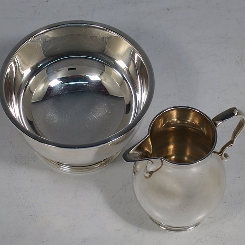 A Sterling Silver sugar and creamer set, having plain round bellied bodies, applied reeded borders, a sparrow-beak spout, and sitting on collet feet. Made by Robert Comyns of London in 1965. The dimensions of this fine hand-made silver sugar and creamer set are height of cream jug 7.5 cms (3 inches), diameter of bowl 9 cms (3.5 inches), and they weigh a total of approx. 225g (7.3 troy ounces).
