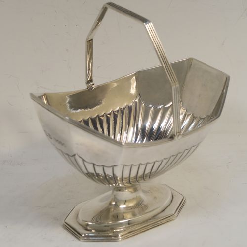 A very pretty Antique Victorian Sterling Silver sugar basket and cream jug set, having Neoclassical style panelled bodies with hand-chased half-fluted decoration, with applied reeded borders, the sugar basket with a swing-handle, and all sitting on pedestal feet. This elegant antique silver cream and sugar set was made by Frederick Elkington of London in 1884. The dimensions of this fine hand-made antique silver sugar and creamer set are height of cream jug 12.5 cms (5 inches), length of sugar basket 12 cms (4.75 inches), with a total weight of approx. 252g (8.1 troy ounces).
