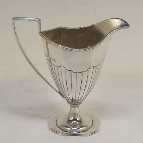 A very pretty Antique Victorian Sterling Silver sugar basket and cream jug set, having Neoclassical style panelled bodies with hand-chased half-fluted decoration, with applied reeded borders, the sugar basket with a swing-handle, and all sitting on pedestal feet. This elegant antique silver cream and sugar set was made by Frederick Elkington of London in 1884. The dimensions of this fine hand-made antique silver sugar and creamer set are height of cream jug 12.5 cms (5 inches), length of sugar basket 12 cms (4.75 inches), with a total weight of approx. 252g (8.1 troy ounces).