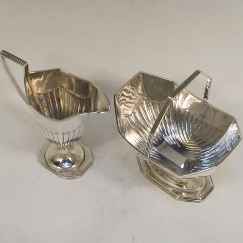 A very pretty Antique Victorian Sterling Silver sugar basket and cream jug set, having Neoclassical style panelled bodies with hand-chased half-fluted decoration, with applied reeded borders, the sugar basket with a swing-handle, and all sitting on pedestal feet. This elegant antique silver cream and sugar set was made by Frederick Elkington of London in 1884. The dimensions of this fine hand-made antique silver sugar and creamer set are height of cream jug 12.5 cms (5 inches), length of sugar basket 12 cms (4.75 inches), with a total weight of approx. 252g (8.1 troy ounces).