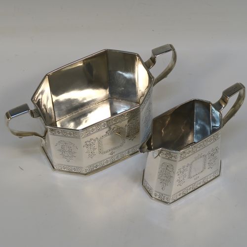 A very pretty Antique Victorian Sterling Silver sugar and creamer set, having octagonal panelled bodies with straight sides and hand-engraved floral decoration, with applied reeded borders, scoll sider handles, and all sitting on flat bases. This beautiful sugar and cream set was made by Henry William Curry of London in 1882. The dimensions of this fine hand-made antique silver cream and sugar set are height of creamer 9.5 cms (3.75 inches), length of sugar bowl 16.5 cms (6.5 inches), and with a total weight approx. 336g (10.8 troy ounces).