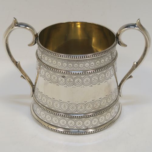 A large, beautiful and heavy Antique Victorian Sterling Silver sugar and creamer set, having round bodies with tapering sides and hand-engraved bright-cut floral decoration, with applied beaded borders, gold-gilt interiors, cast scroll side-handles, and all sitting on flat bases. This very pretty sugar and cream set was made by the Bradbury Brothers of London in 1869. The dimensions of this fine hand-made antique silver cream and sugar set are height of creamer 11.5 cms (4.5 inches), diameter of sugar bowl 10 cms (4 inches), and with a total weight approx. 639g (21 troy ounces).