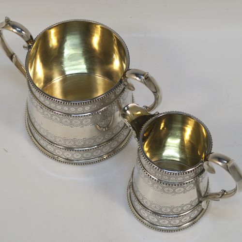 A large, beautiful and heavy Antique Victorian Sterling Silver sugar and creamer set, having round bodies with tapering sides and hand-engraved bright-cut floral decoration, with applied beaded borders, gold-gilt interiors, cast scroll side-handles, and all sitting on flat bases. This very pretty sugar and cream set was made by the Bradbury Brothers of London in 1869. The dimensions of this fine hand-made antique silver cream and sugar set are height of creamer 11.5 cms (4.5 inches), diameter of sugar bowl 10 cms (4 inches), and with a total weight approx. 639g (21 troy ounces).