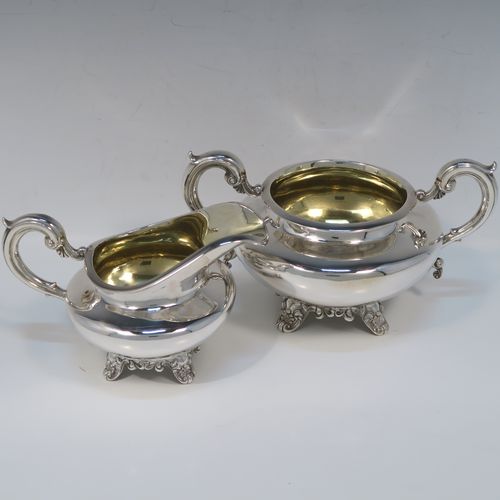 A very elegant Antique Victorian Sterling Silver sugar and creamer set, having plain round bellied bodies, with gold-gilt interiors and scroll handles, and all sitting on four scroll and shell feet. This handsome silver sugar and cream set was made by Benoni Stephens of London in 1861. The dimensions of this fine hand-made antique silver cream jug and sugar bowl set are height of cream jug 10 cms (4 inches), diameter of sugar bowl 14 cms (5.5 inches), and the total weight is approx. 593g (19 troy ounces).

   