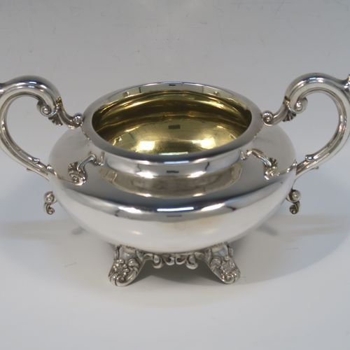A very elegant Antique Victorian Sterling Silver sugar and creamer set, having plain round bellied bodies, with gold-gilt interiors and scroll handles, and all sitting on four scroll and shell feet. This handsome silver sugar and cream set was made by Benoni Stephens of London in 1861. The dimensions of this fine hand-made antique silver cream jug and sugar bowl set are height of cream jug 10 cms (4 inches), diameter of sugar bowl 14 cms (5.5 inches), and the total weight is approx. 593g (19 troy ounces).

   