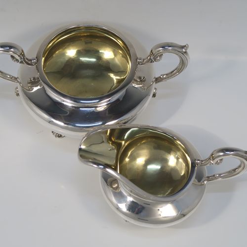A very elegant Antique Victorian Sterling Silver sugar and creamer set, having plain round bellied bodies, with gold-gilt interiors and scroll handles, and all sitting on four scroll and shell feet. This handsome silver sugar and cream set was made by Benoni Stephens of London in 1861. The dimensions of this fine hand-made antique silver cream jug and sugar bowl set are height of cream jug 10 cms (4 inches), diameter of sugar bowl 14 cms (5.5 inches), and the total weight is approx. 593g (19 troy ounces).

   