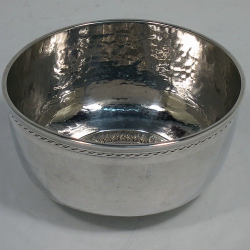 A very attractive Arts and Crafts Sterling Silver sugar and creamer set, having round bodies with hand-hammered plenished decoration, with applied reeded and rope-twist top borders, all sitting on flat bases. Made by Edward Spencer of the Artificiers Guild of London in 1928. The dimensions of this fine hand-made Arts and Crafts silver sugar and creamer set are diameter of sugar bowl 9 cms (3.5 inches), height of cream jug 7 cms (2.75 inches), with a total weight of 173g (5.6 troy ounces).