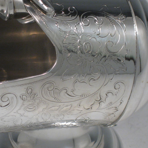 Antique Victorian silver-plated sugar scuttle, having a hand-engraved body with floral decoration, two cast scroll handles, an original scoop, and sitting on a pedestal foot. Made in ca. 1890. The dimensions of this fine hand-made silver-plated sugar scuttle are length 15 cms (6 inches), height 11.5 cms (4.5 inches), and width 7.5 cms (3 inches).