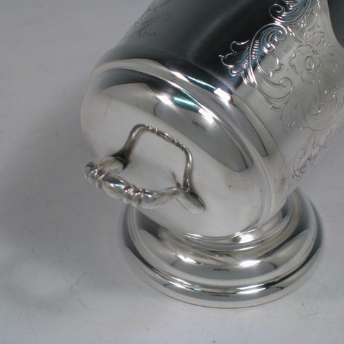 Antique Victorian silver-plated sugar scuttle, having a hand-engraved body with floral decoration, two cast scroll handles, an original scoop, and sitting on a pedestal foot. Made in ca. 1890. The dimensions of this fine hand-made silver-plated sugar scuttle are length 15 cms (6 inches), height 11.5 cms (4.5 inches), and width 7.5 cms (3 inches).