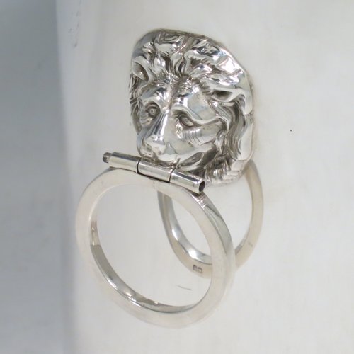 A Sterling Silver syphon stand, having a plain cylindrical body, two side-hinged ring handles with lion mask mounts, an applied reed and ribbon border, and sitting on a plain collet foot. Made by Britton, Gould & Co., of Birmingham in 1930. The dimensions of this fine hand-made silver siphon stand are diameter 13 cms (5 inches), height 14 cms (5.5 inches), and it weighs approx. 420g (13.5 troy ounces).