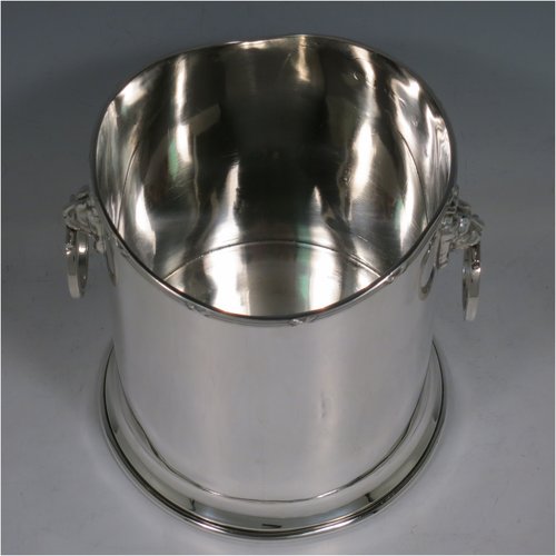 A Sterling Silver syphon stand, having a plain cylindrical body, two side-hinged ring handles with lion mask mounts, an applied reed and ribbon border, and sitting on a plain collet foot. Made by Britton, Gould & Co., of Birmingham in 1930. The dimensions of this fine hand-made silver siphon stand are diameter 13 cms (5 inches), height 14 cms (5.5 inches), and it weighs approx. 420g (13.5 troy ounces).