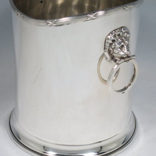 A Sterling Silver syphon stand, having a plain cylindrical body, two side-hinged ring handles with lion mask mounts, an applied reed and ribbon border, and sitting on a plain collet foot. Made by Britton, Gould & Co., of Birmingham in 1930. The dimensions of this fine hand-made silver siphon stand are diameter 13 cms (5 inches), height 14 cms (5.5 inches), and it weighs approx. 420g (13.5 troy ounces).