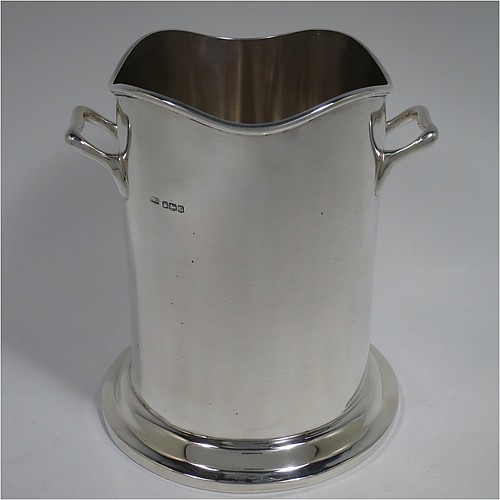 A Sterling Silver pair of syphon stands or champagne / wine bottle holders, having plain round bodies with straight sides, with two cast scroll side-handles, applied wavey-edge reeded borders, and sitting on collet feet. Made by Emile Viner of Sheffield in 1932/33. The dimensions of these fine hand-made silver wine / champagne bottle holders or siphon stands are diameter 12 cms (4.75 inches), height 17 cms (6.75 inches), and they weigh a total of approx. 1,296g (42 troy ounces).