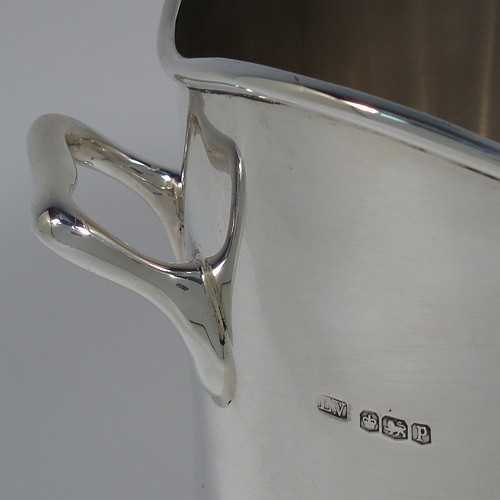 A Sterling Silver pair of syphon stands or champagne / wine bottle holders, having plain round bodies with straight sides, with two cast scroll side-handles, applied wavey-edge reeded borders, and sitting on collet feet. Made by Emile Viner of Sheffield in 1932/33. The dimensions of these fine hand-made silver wine / champagne bottle holders or siphon stands are diameter 12 cms (4.75 inches), height 17 cms (6.75 inches), and they weigh a total of approx. 1,296g (42 troy ounces).